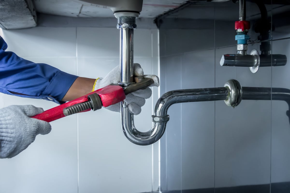 Professional plumber removing drain clog